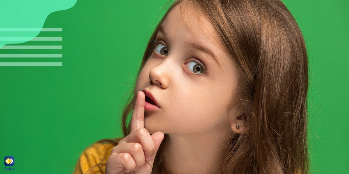 Kleines Mädchen hält den Finger vor die Lippen, als hätte sie ein Geheimnis