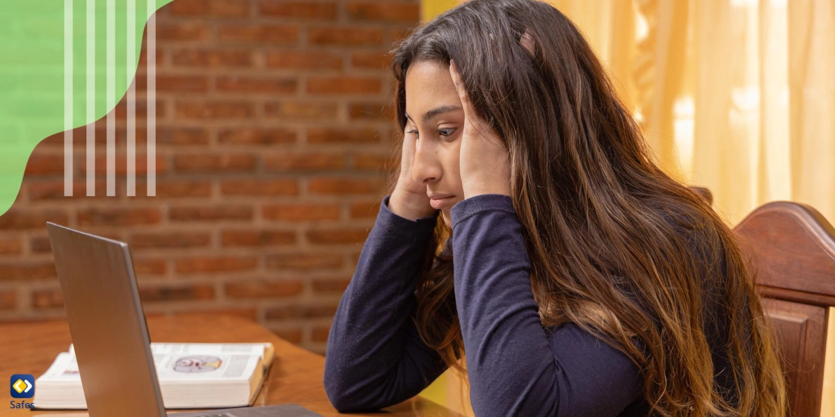 Teenage girl sitting in front of a laptop with her hands in her hair