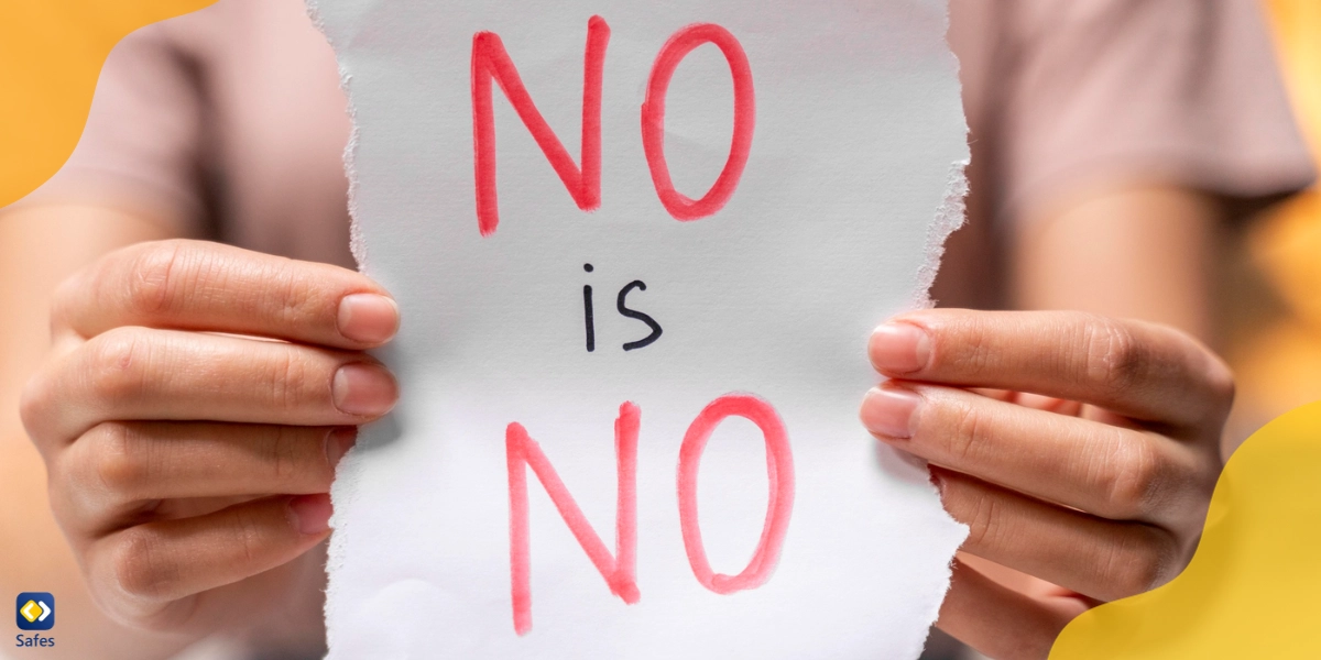 Teenage girl holding a sign that reads “No Is No” to emphasize the importance of teaching consent to children.