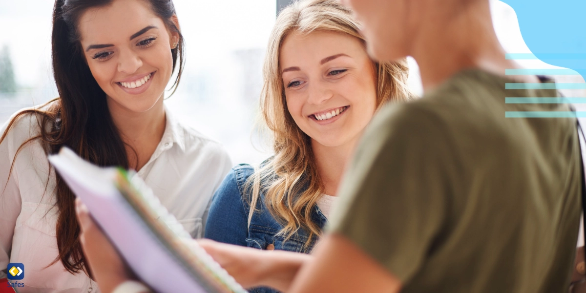 Two students smiling as they listen to their teacher