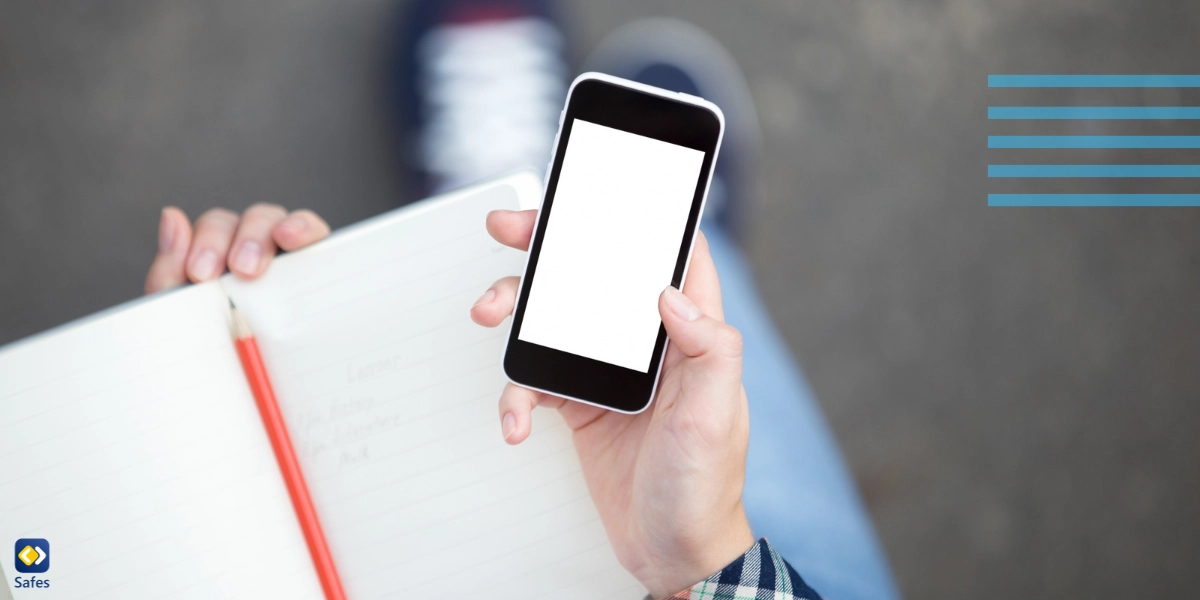 A student holding a smartphone against an open notebook