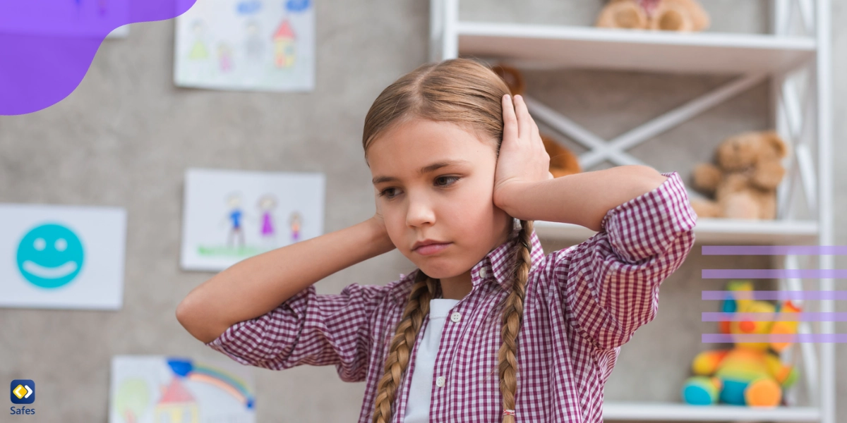 Small girl holding her hands on her ears because of sensory overload disorder