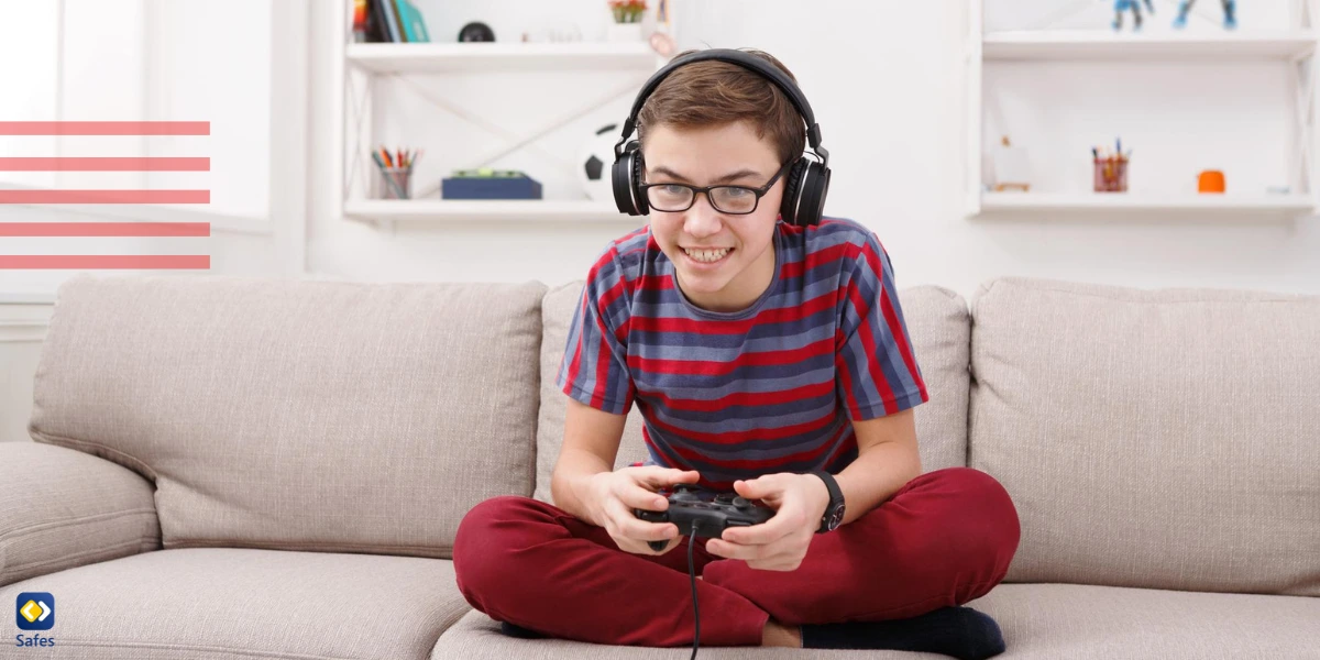 Teenage boy playing video games with controller on a sofa with a headset