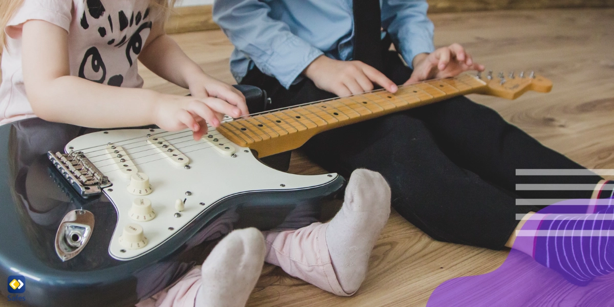 Kleiner Junge und Mädchen spielen an einer E-Gitarre herum