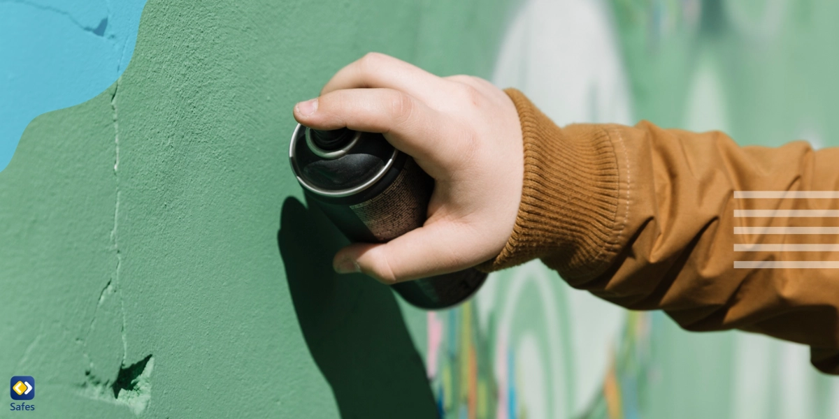 Consequences of vandalizing schools shown by a teen using graffiti on school property