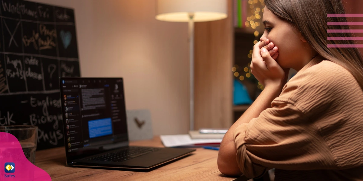 A teenage girl experiencing cyberbullying, sitting behind her laptop.