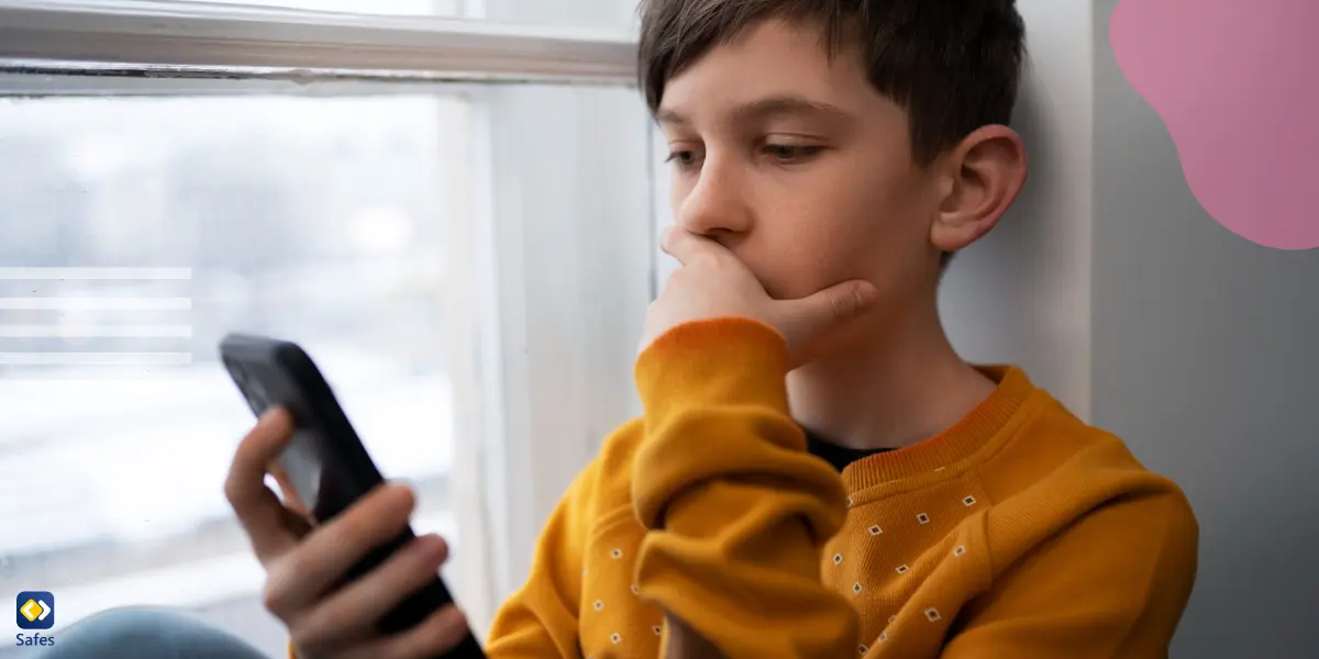 a young boy staring at his cell phone anxiously