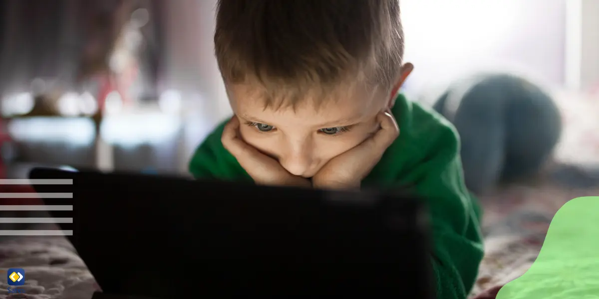 Ein kleiner Junge, der auf den Bildschirm eines Laptops starrt und sich unangemessene Inhalte im Internet ansieht.