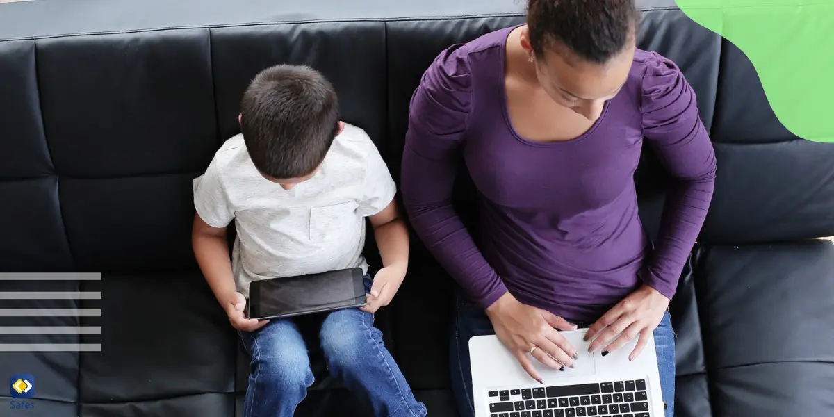 Ein Junge schaut sich Videos im Internet an und ihre Mutter neben ihr arbeitet mit einem Laptop und kann sich darauf verlassen, dass ihr Sohn dank der Webfilterung keinen unangemessenen Inhalten ausgesetzt ist.