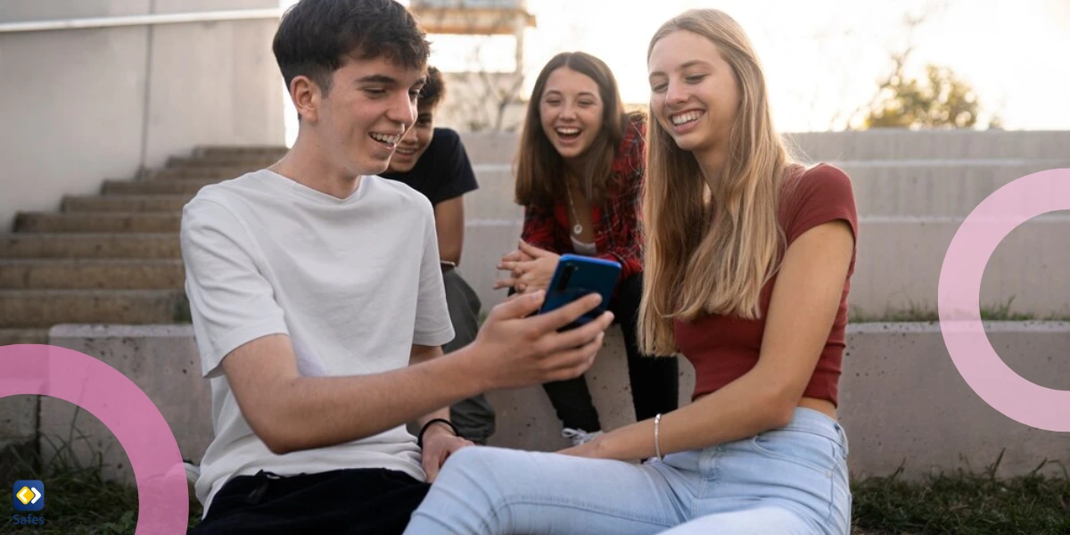 teenagers laughing and showing something on a phone to each other