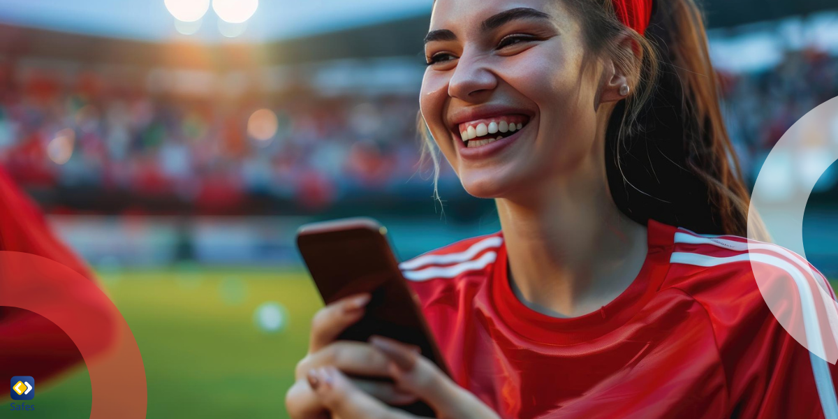 An Arsenal Team fan is celebrating victory with a phone in her hand.