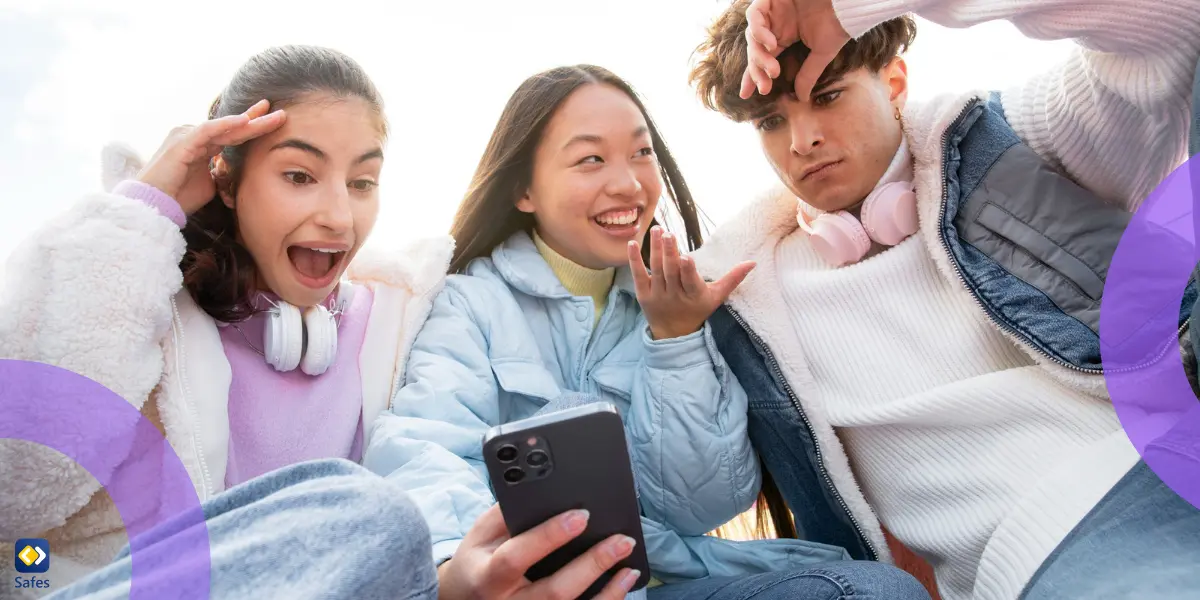 Teenagers having fun together and showing each other something on their phone.