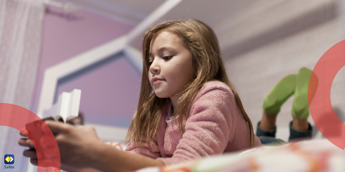 A girl using a smartphone on a bed.
