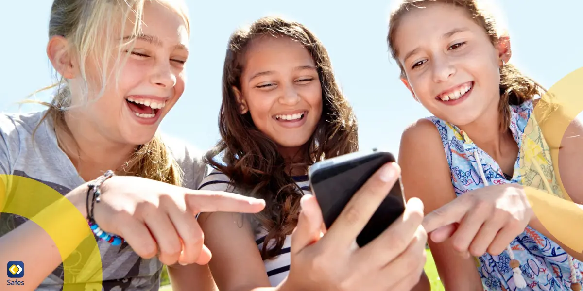 three girls using a smartphone and laughing