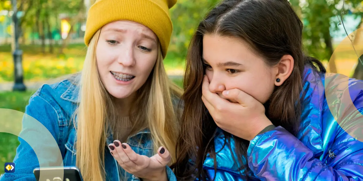 girl with braces showing something on her phone to her shocked friend
