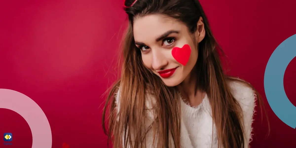 teen girl holding phone with a heart on it and hearts on her cheeks